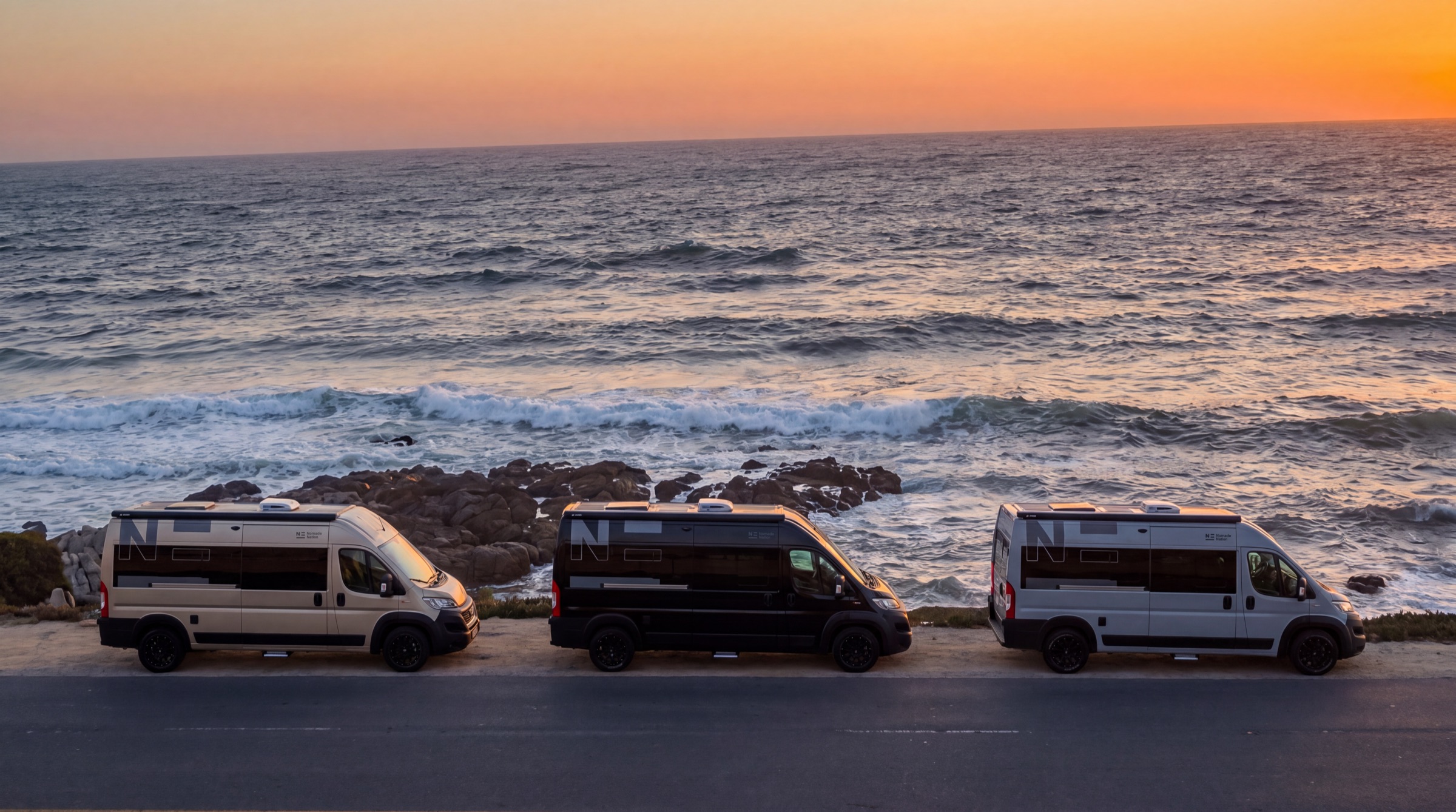 Trois campers Nomade face à la mer au coucher du soleil
